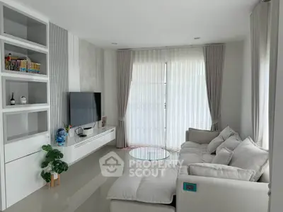 Modern living room with sleek design, large windows, and cozy seating area.