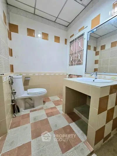 Spacious bathroom with modern fixtures and large mirror in a stylish home.