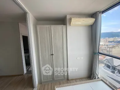 Bright bedroom with large window and air conditioning, offering a scenic city view.