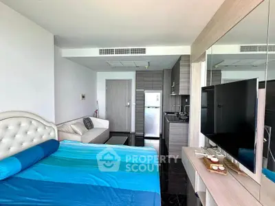 Modern studio apartment with stylish decor, featuring a cozy bed, sleek kitchen, and comfortable living area.