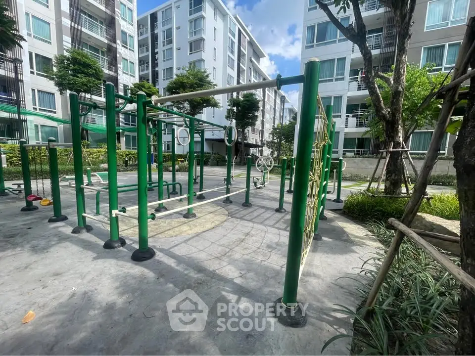 Modern apartment complex with outdoor fitness area and lush greenery.