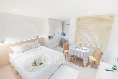 Bright and cozy bedroom with dining area, modern decor, and ample storage space.