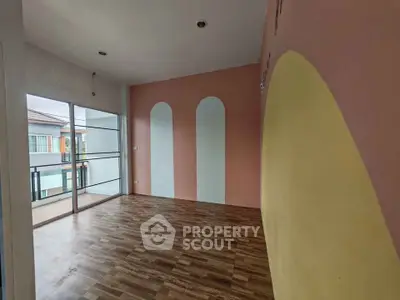 Spacious room with unique wall design and large windows leading to a balcony, perfect for modern living.