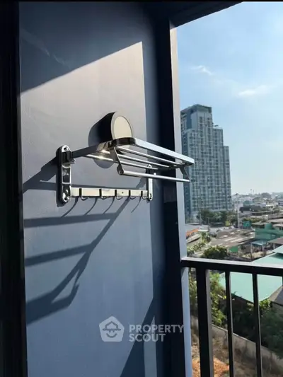 Modern balcony with city view and sleek wall-mounted drying rack.