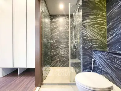Modern bathroom with sleek marble walls and glass shower enclosure
