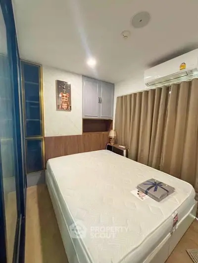 Cozy bedroom with modern decor and air conditioning, featuring a comfortable bed and stylish lighting.