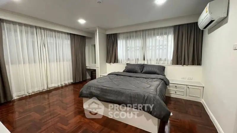 Spacious bedroom with elegant wooden flooring and modern decor