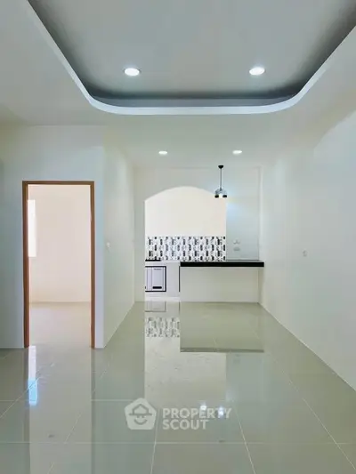 Modern open-layout kitchen with sleek tile flooring and stylish lighting fixtures.