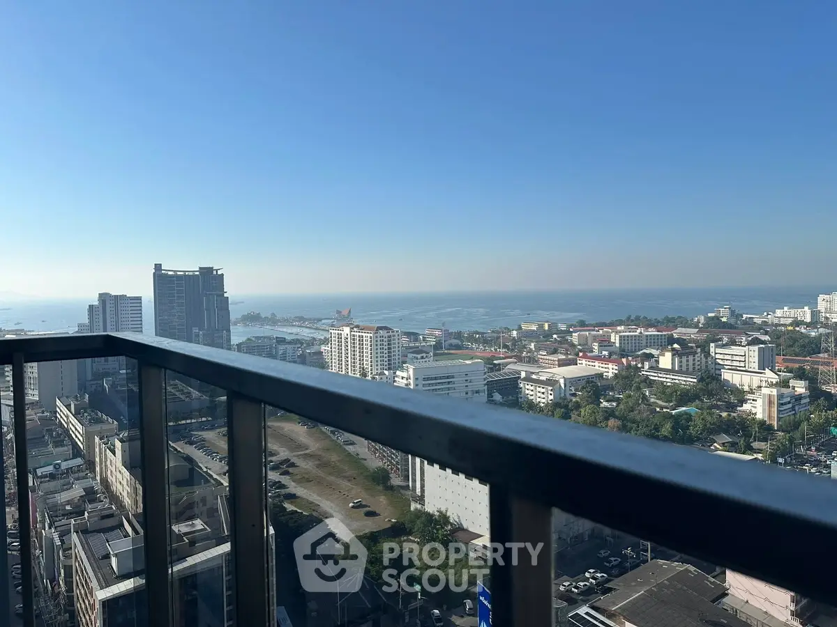 Stunning high-rise balcony view overlooking cityscape and ocean horizon.