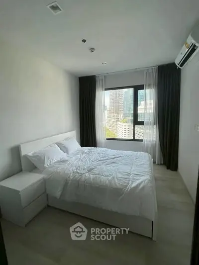 Modern bedroom with city view, featuring a cozy bed and elegant curtains in a high-rise apartment.