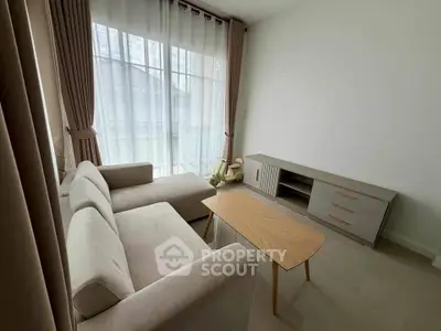 Modern living room with elegant sofa and natural light, perfect for relaxation and entertainment.