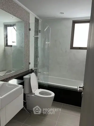 Modern bathroom with sleek design, featuring a bathtub and large mirror, perfect for relaxation and style.