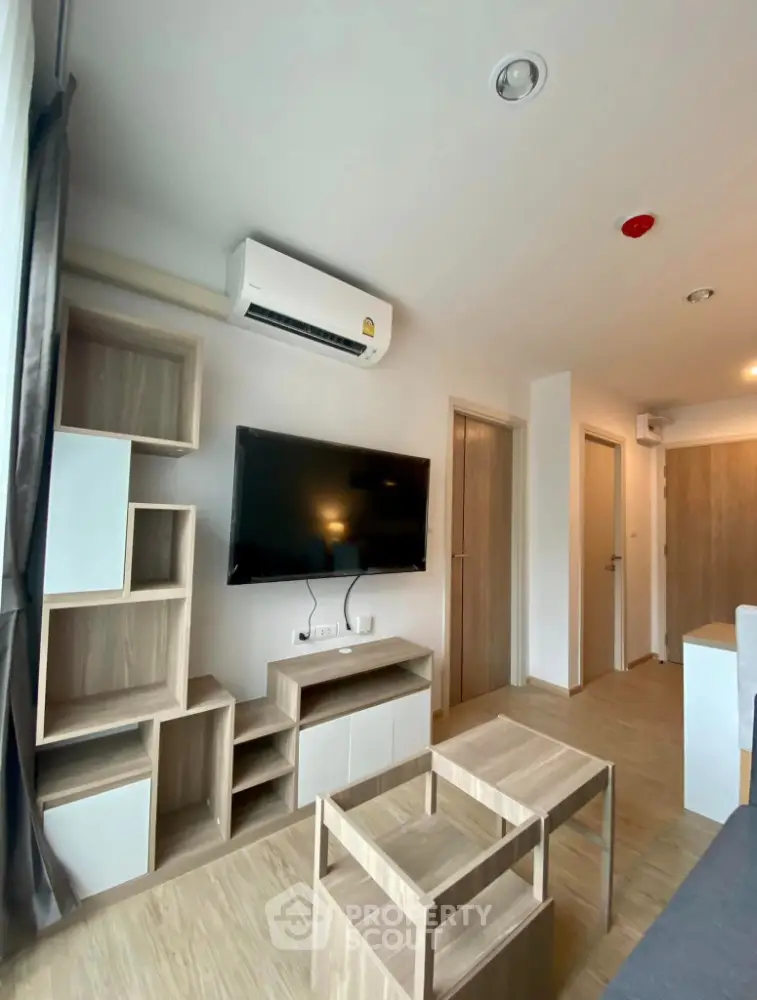 Modern living room with stylish wooden furniture and wall-mounted TV in a cozy apartment.