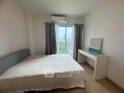 Cozy bedroom with city view, featuring a large window and modern furnishings.
