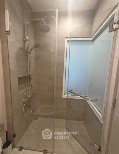 Modern bathroom with glass shower enclosure and sleek fixtures