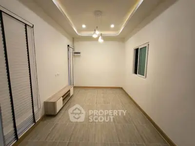 Spacious unfurnished room with modern lighting and large windows, perfect for customization.