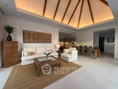 Luxurious open-plan living room with elegant wooden ceiling beams and modern decor.