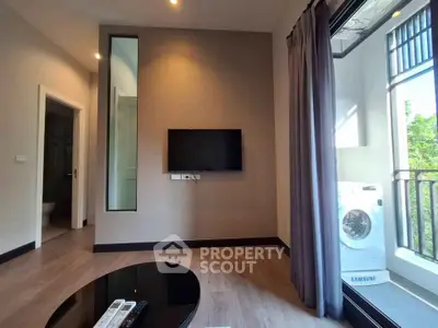 Modern living room with wall-mounted TV and balcony view