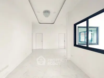 Spacious white interior with modern lighting and large window, ideal for customization.