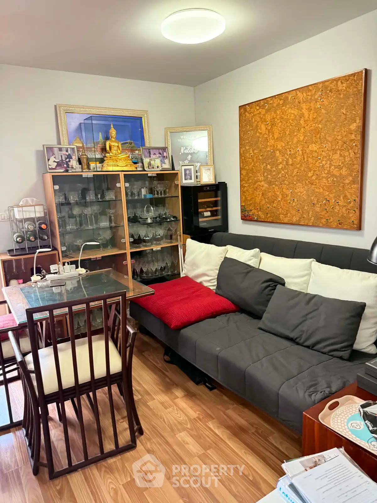Cozy living room with stylish decor and glass cabinet, perfect for relaxation and entertaining.