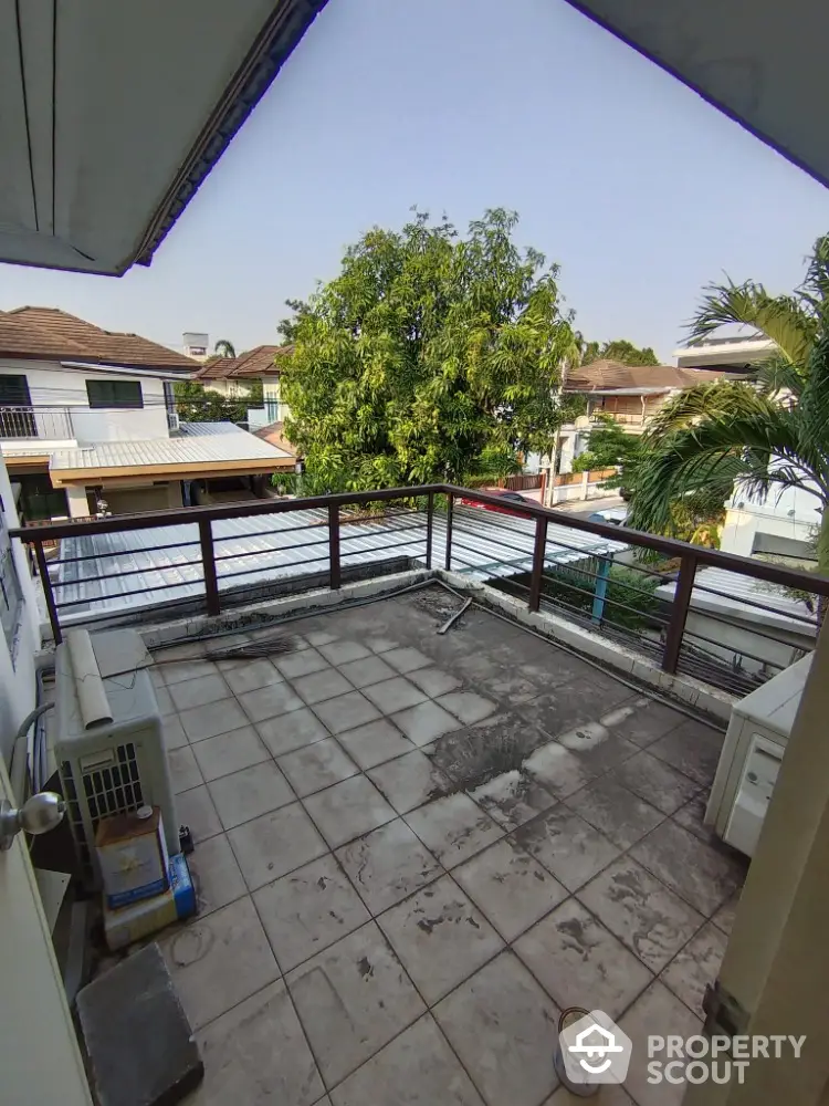 Spacious balcony with potential for customization, offering a serene tree-lined view in a residential neighborhood, perfect for outdoor relaxation.