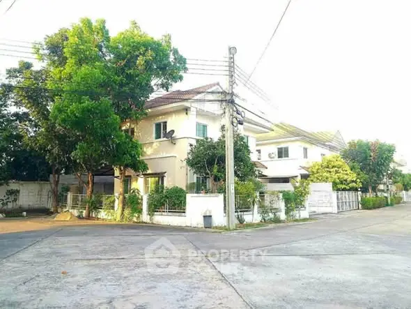 Charming suburban house with lush greenery and spacious driveway in a peaceful neighborhood.