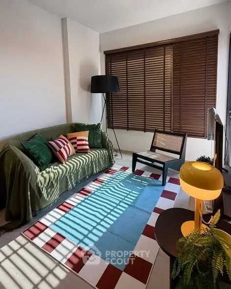 Charming living room with cozy sofa, stylish decor, and abundant natural light through large windows.