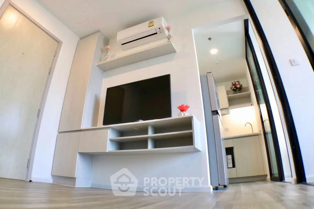 Modern living room with sleek TV unit and open kitchen layout