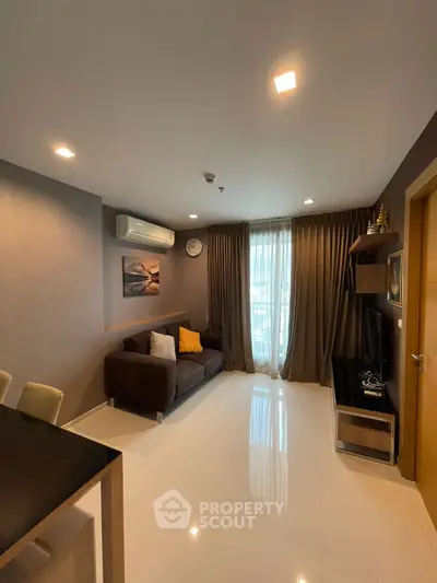 Modern living room with cozy sofa, wall-mounted TV, and elegant curtains.