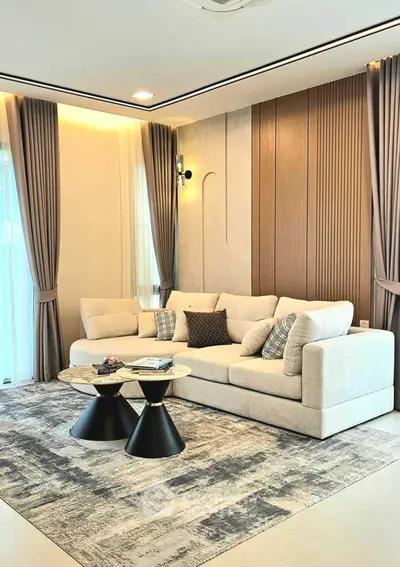 Elegant living room with modern decor, featuring a plush sofa and stylish coffee tables.