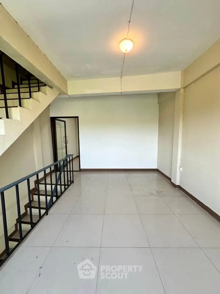 Spacious living room with staircase and modern design, perfect for urban living.