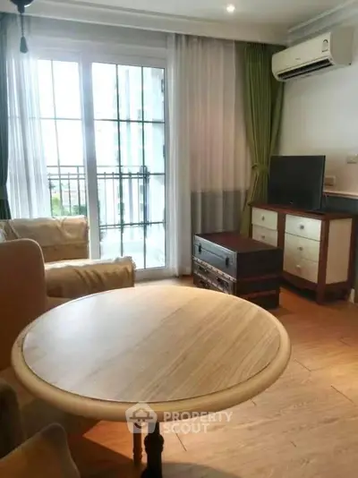 Charming living room with balcony access, featuring elegant furniture and natural light.