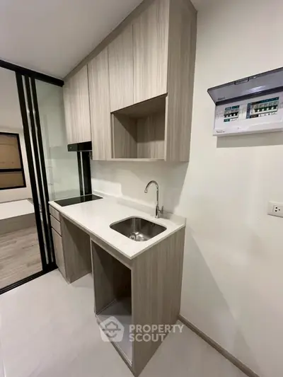 Modern compact kitchen with sleek cabinetry and electric stove