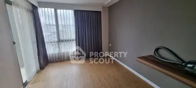 Spacious empty room with large windows and wooden flooring, perfect for customization.
