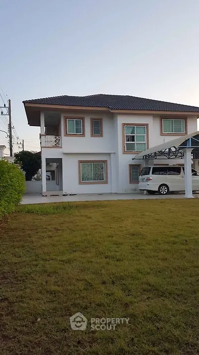 Charming two-story house with spacious lawn and carport in a serene neighborhood.