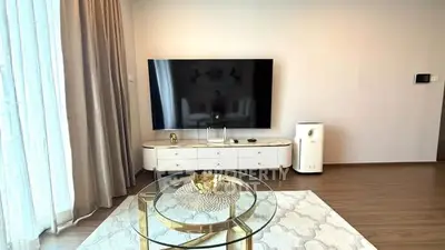 Modern living room with sleek TV setup and elegant glass coffee table.