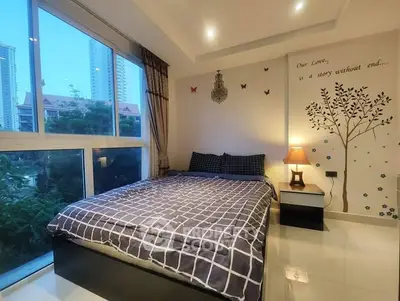 Cozy bedroom with large window and stylish decor in modern apartment