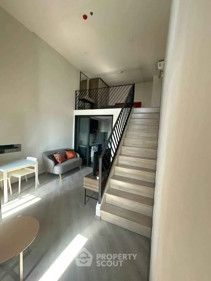 Modern loft apartment with mezzanine, stylish staircase, and cozy living area.