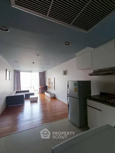 Spacious open-layout living room with modern kitchen, perfect for urban living.