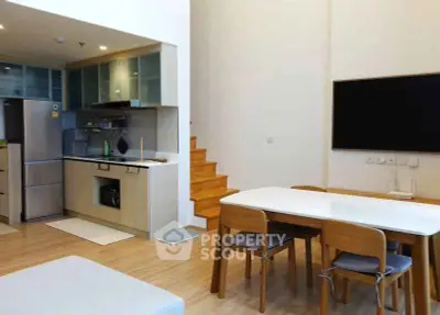 Modern open-plan kitchen and dining area with sleek design and wooden accents.