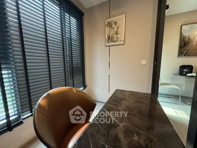 Modern study room with marble desk and stylish chair, featuring large windows with blinds for natural light.