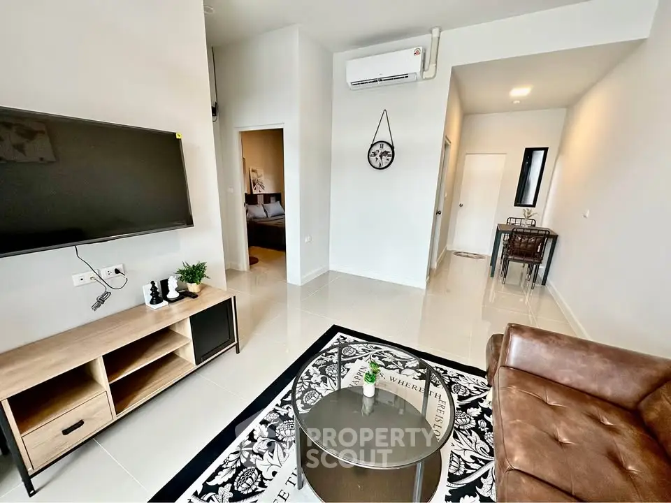 Modern living room with stylish decor, leather sofa, and wall-mounted TV in a contemporary apartment.