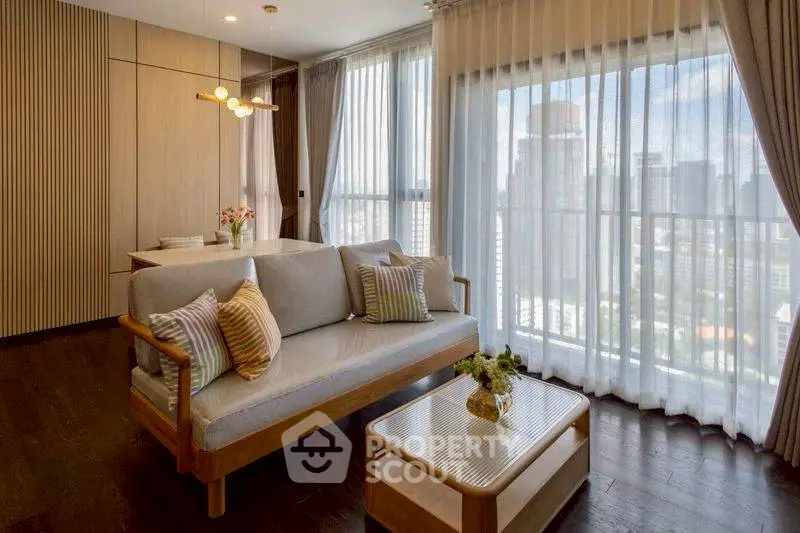 Elegant living room with city view, featuring modern furniture and floor-to-ceiling windows.