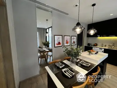 Modern kitchen with stylish island and dining area, featuring pendant lighting and contemporary decor.