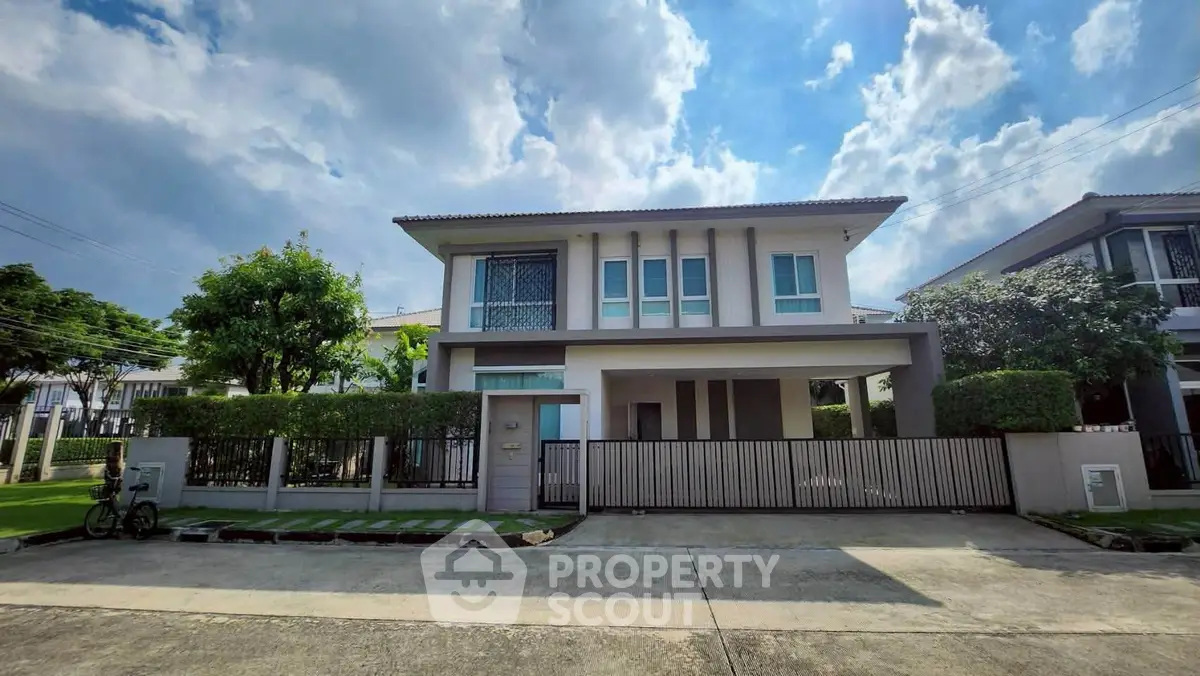 Stunning modern two-story house with lush greenery and spacious driveway in a serene neighborhood.