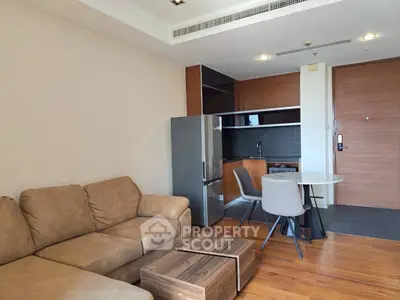 Modern apartment living room with cozy sofa and compact kitchen area.