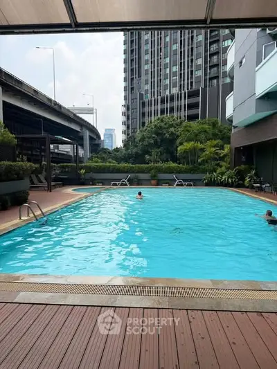 Luxurious urban apartment complex with a stunning outdoor pool and city views.