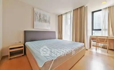 Spacious bedroom with large windows and modern decor in a high-rise apartment.
