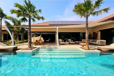 Luxurious villa with stunning pool and palm trees, perfect for tropical living.