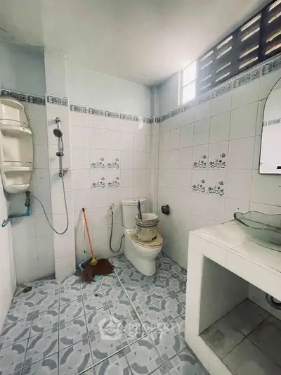 Spacious bathroom with modern fixtures and tiled walls, perfect for a refreshing start to your day.